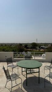 a green table and chairs on a patio at Sheopur Shikaar Oudi in Sheodāspura