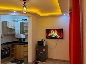 a kitchen with a fire in a tv on the wall at Luxe 1 bedroom chui Villa View in Munyu