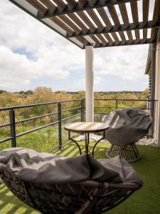 a balcony with a table and chairs and a view at Appartement de L'Espiguette in Le Grau-du-Roi
