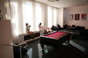 two women sitting in a room with a pool table at Little Drifter North Melbourne in Melbourne