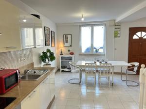 a kitchen with a white table and chairs in it at Le P'ti Mignat - Jolie maison avec terrasse in Suèvres