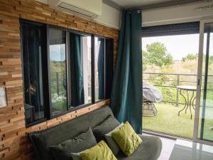 a living room with a couch and a balcony at Appartement de L'Espiguette in Le Grau-du-Roi