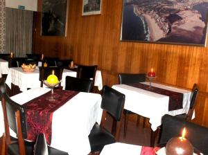 a dining room with white tables and chairs with candles at Sao Roque in Portimão