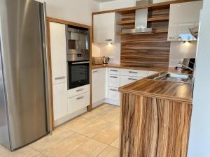a kitchen with white cabinets and a stainless steel refrigerator at Mona Apartment in Going am Wilden Kaiser