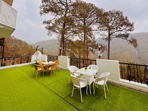 博瓦利Sitara Ambience Resort Halwani-Kaichi dham Bypass Road的草原上带桌椅的阳台 更多21张照片