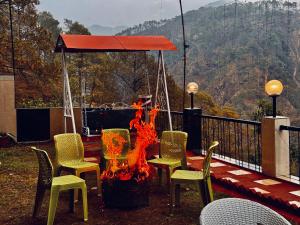 博瓦利Sitara Ambience Resort Halwani-Kaichi dham Bypass Road的甲板上火坑周围的一组椅子