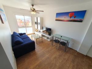 a living room with a blue couch and a table at 3E, 56m2, Aire Acond, 1 dormit, 4 huéspedes, WIFI GRATIS in La Línea de la Concepción