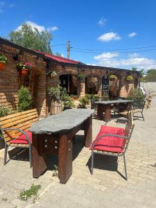a picnic table and benches in front of a brick building at Penzion Kristýna in Hrušovany nad Jevišovkou