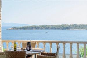 a table on a balcony with a view of the water at Prizba Tomas in Blato