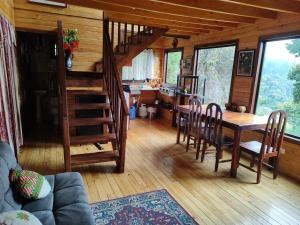 a living room with a table and a dining room at El Quetzalito Cabin in San Gerardo de Dota