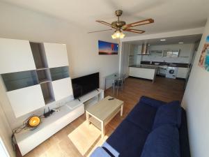 a living room with a blue couch and a table at 3E, 56m2, Aire Acond, 1 dormit, 4 huéspedes, WIFI GRATIS in La Línea de la Concepción