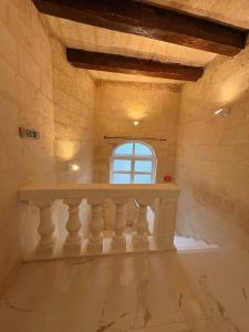 a room with a window and a stone wall at Traditional Maltese Family Townhouse - Cospicua in Cospicua +34 photos