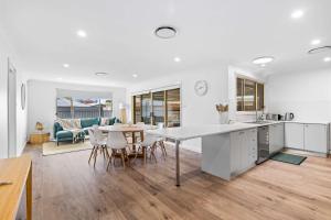 a kitchen and living room with a table and chairs at Caves Beach House by Coast Hosting in Caves Beach