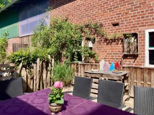 un patio avec une table et des chaises et un mur de briques dans l'établissement Ferienhaus WALDBLICK by fewo-plan WING142 Nähe Naturpark Wingst, à Armstorf