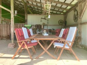 - une table et des chaises en bois dans une grange dans l'établissement Ferienhaus WALDBLICK by fewo-plan WING142 Nähe Naturpark Wingst, à Armstorf 42 autres photos