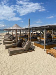 a row of lounge chairs and umbrellas on a beach at Blue Breeze Apart-Danai B in Ofrínion