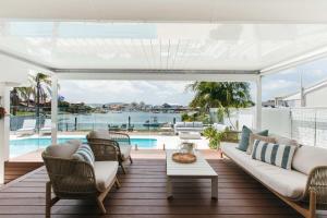 an outdoor patio with a couch and chairs and a pool at MainSail by Coast Hosting in Daleys Point