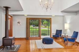 a living room with a wood stove and blue chairs at The Manor by Coast Hosting in Holgate +15 photos