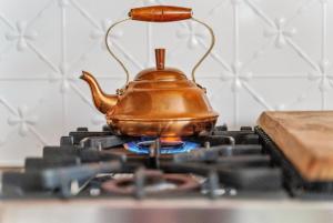 a tea kettle sitting on top of a stove at Cosy Family Farm Stay - Daily Animal Feeding in Wamberal