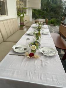 a long white table with plates and flowers on it at VITS Kunjham Retreat in Gangtok