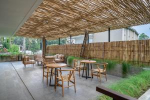 un patio avec tables et chaises et une clôture en bois dans l'établissement Happiness Apartment 1 - Wake Up in Paradise - Live in Ubuds Best Spot, à Ubud