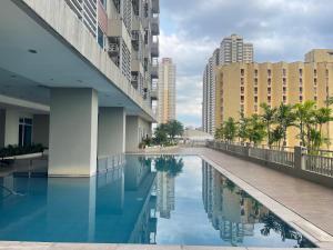 une piscine au milieu d'une ville avec des bâtiments dans l'établissement Condo in Ermita near UP-PGH, St Lukes & US Embassy, à Manille
