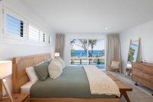 Un dormitorio con una cama con vista al mar. en The Glass House by Coast Hosting, en Copacabana