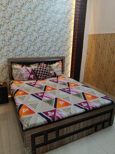 a bed with a colorful quilt on it in a room at Anjani Home - 3Bhk Homely & GroundFloor Appartment for Families in Varanasi +36 photos