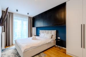 a bedroom with a large bed with a blue headboard at 4friendscoresibrasov M&L in Braşov