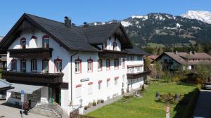 a large white building with a black roof at Ferienwohnungen im Färberhaus in Fischen