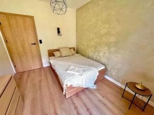 a small bedroom with a bed and a wooden floor at Siedlisko Kochówka in Pszczew