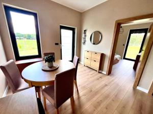 a dining room with a table and chairs and a bedroom at Siedlisko Kochówka in Pszczew