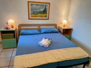 ein Schlafzimmer mit einem blauen Bett und zwei Nachttischen in der Unterkunft Casa Margot Costa Verde Sardinia in Torre Dei Corsari