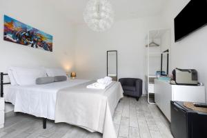 Cette chambre blanche dispose de 2 lits et d'une télévision. dans l'établissement Camere Amè, à Peschiera del Garda