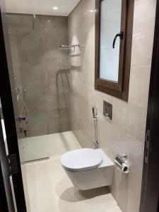 a bathroom with a toilet and a shower at Lilly Lagoon Townhouse in Ţāqah +10 photos