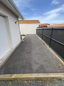 a driveway outside a house with a fence at Maison Proche Centre Ville in Biscarrosse +1 photo