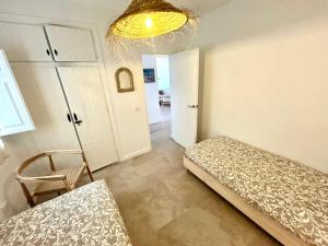a bedroom with a bed and a chair and a chandelier at AguaCabana in Agua Amarga