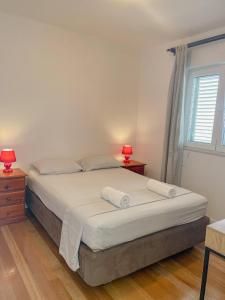 a bedroom with a bed with two lamps and a window at Prizba Tomas in Blato