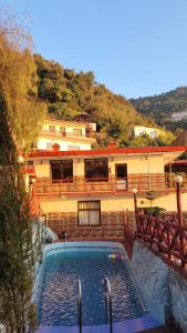 a swimming pool in front of a building at New Orange Tree Classic Fall in Mussoorie with pool & parking in Mussoorie