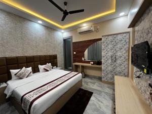 a hotel room with a bed and a television at Hotel Atithi Food Village in Etāwah