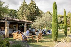 a group of people sitting in chairs in a yard at LA FERME DE LA HUPPE in Gordes