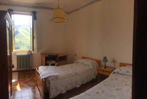 a bedroom with two beds and a window at Albergo Ristorante La Selva in Orsigna