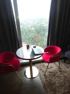 a table with a laptop and two chairs in front of a window at Aeon Towers Luxury Suites in Davao City