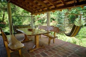 a porch with a hammock and a table and chairs at Kuća za odmor EDEN in Cernik