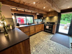 a kitchen with wooden cabinets and a stove top oven at Chalet Le Nutshell - 4pers - Vue montagne au calme - Proche Annecy, La Clusaz, Grand-Bornand - AravisTour in Thônes