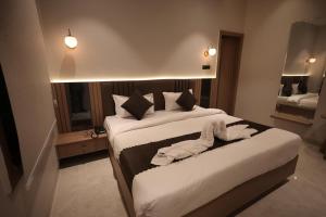 a hotel room with two beds with towels on them at Hotel Umang Palace in Bhopal