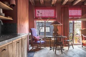 ブルージュにあるOdevaere - Charming & luxurious apartment with terraceの赤いカーテン、テーブルと椅子付きのキッチン