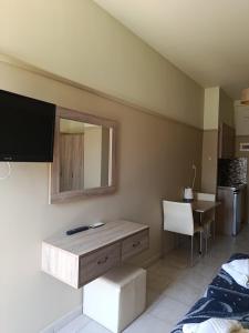 a room with a television and a table and a chair at Kleri Beloni Rooms in Chania Town
