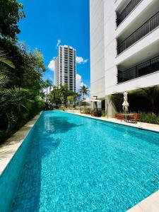a large blue swimming pool next to a building at GRU Airport 4km, 2 Dorms, Bosque Maia in Guarulhos