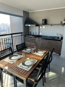 a dining room table with chairs and a kitchen at GRU Airport 4km, 2 Dorms, Bosque Maia in Guarulhos